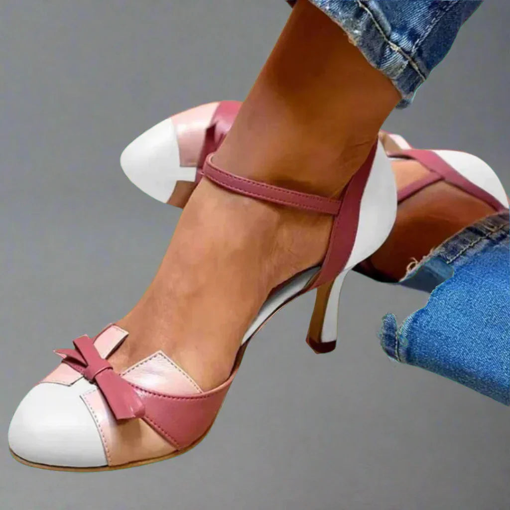 Classic women's pumps with a block heel featuring bow embellishments. 2