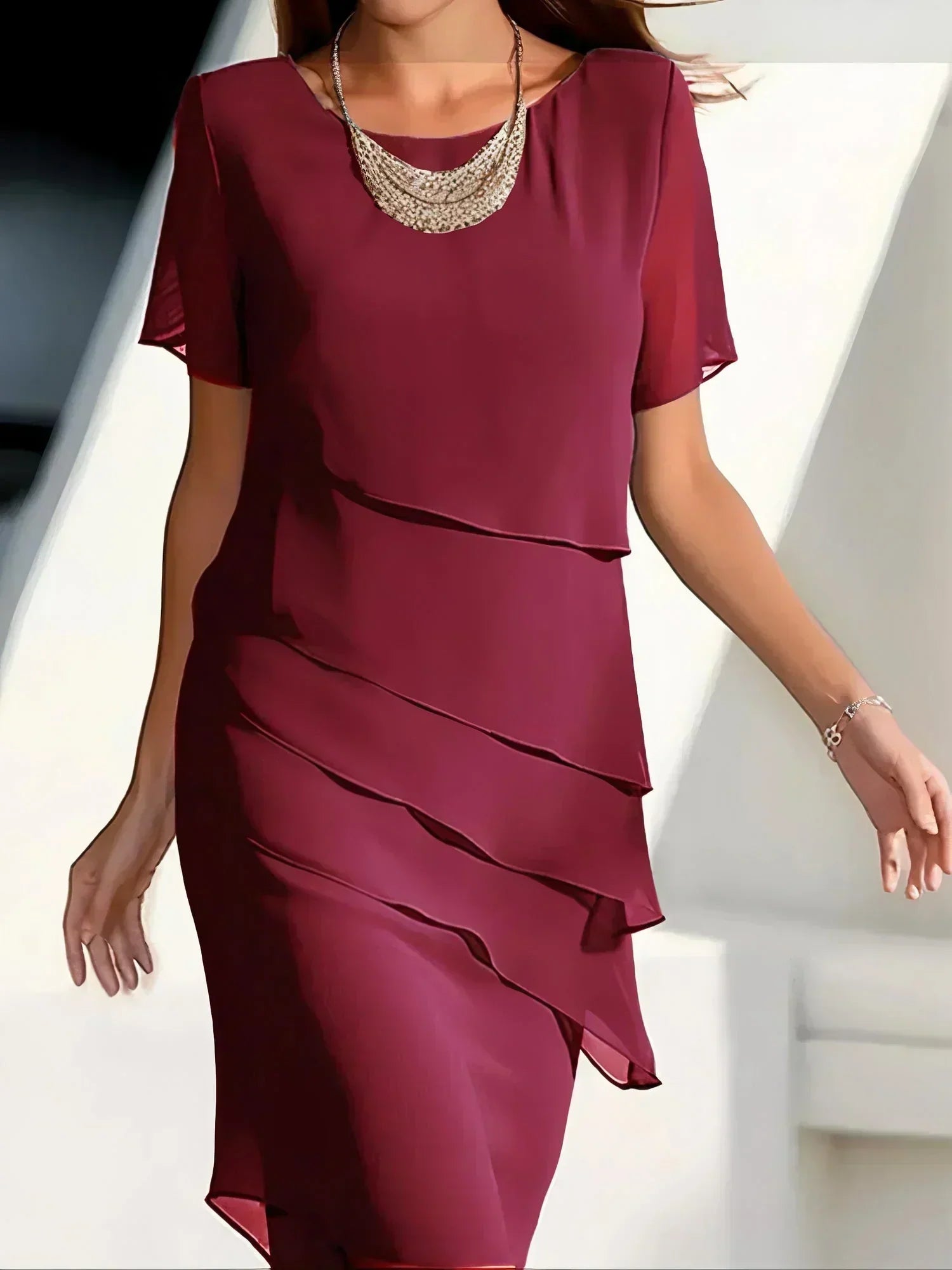 A mid-length evening dress designed for women, featuring a structured waistline and a flowing skirt. The dress has a fitted bodice and offers a sophisticated 1