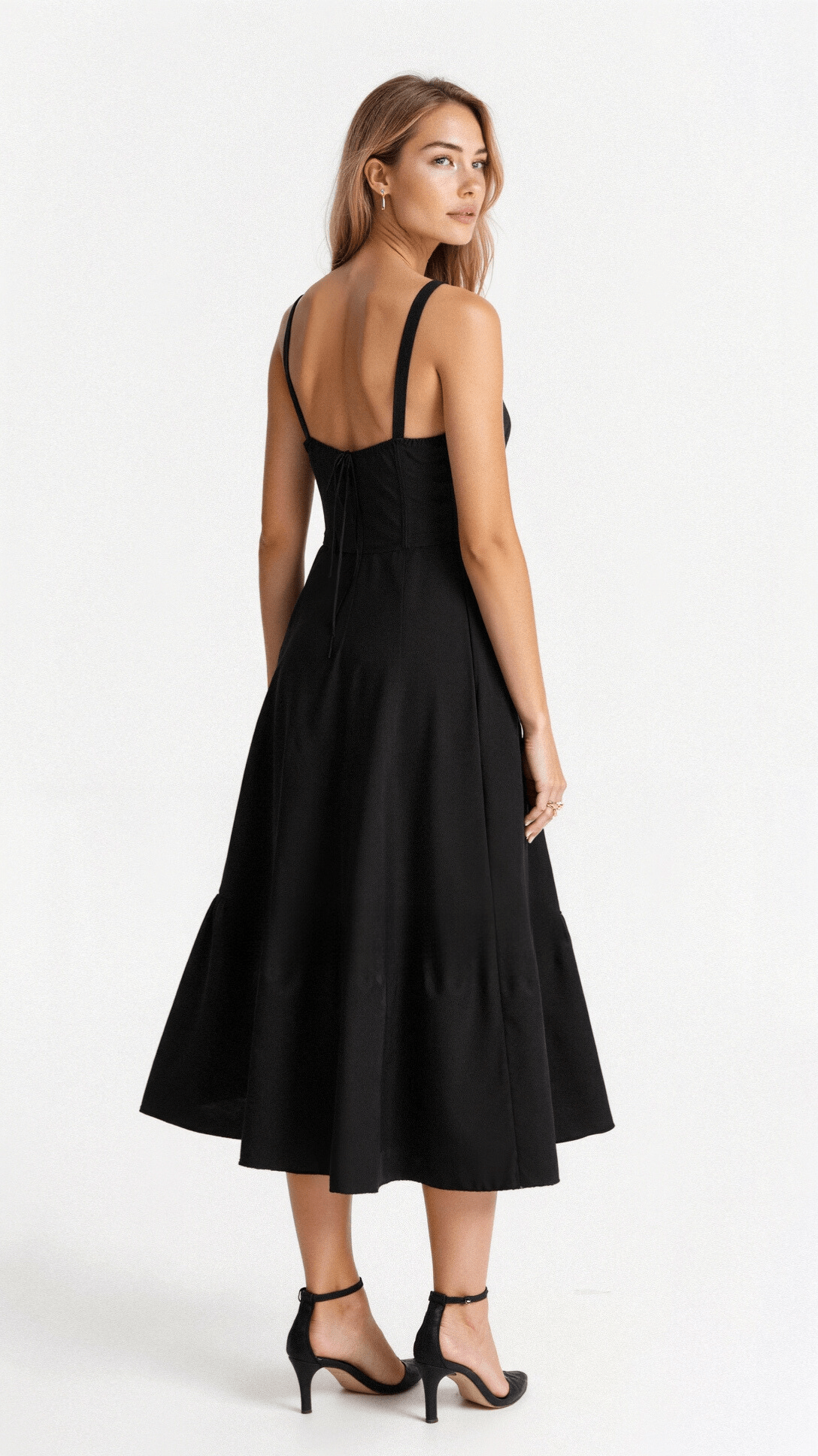 A woman wearing a midi dress with a fitted bodice and a flowing skirt, suitable for a wedding. The dress features a corset-style top and 3