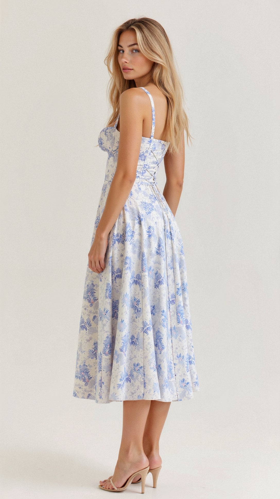 A woman wearing a midi dress with a fitted bodice and a flowing skirt, suitable for a wedding. The dress features a corset-style top and 7