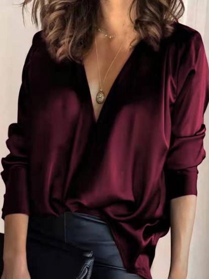 Elegant women's blouse with a V-neck and long sleeves, featuring a fitted design and subtle detailing. 1