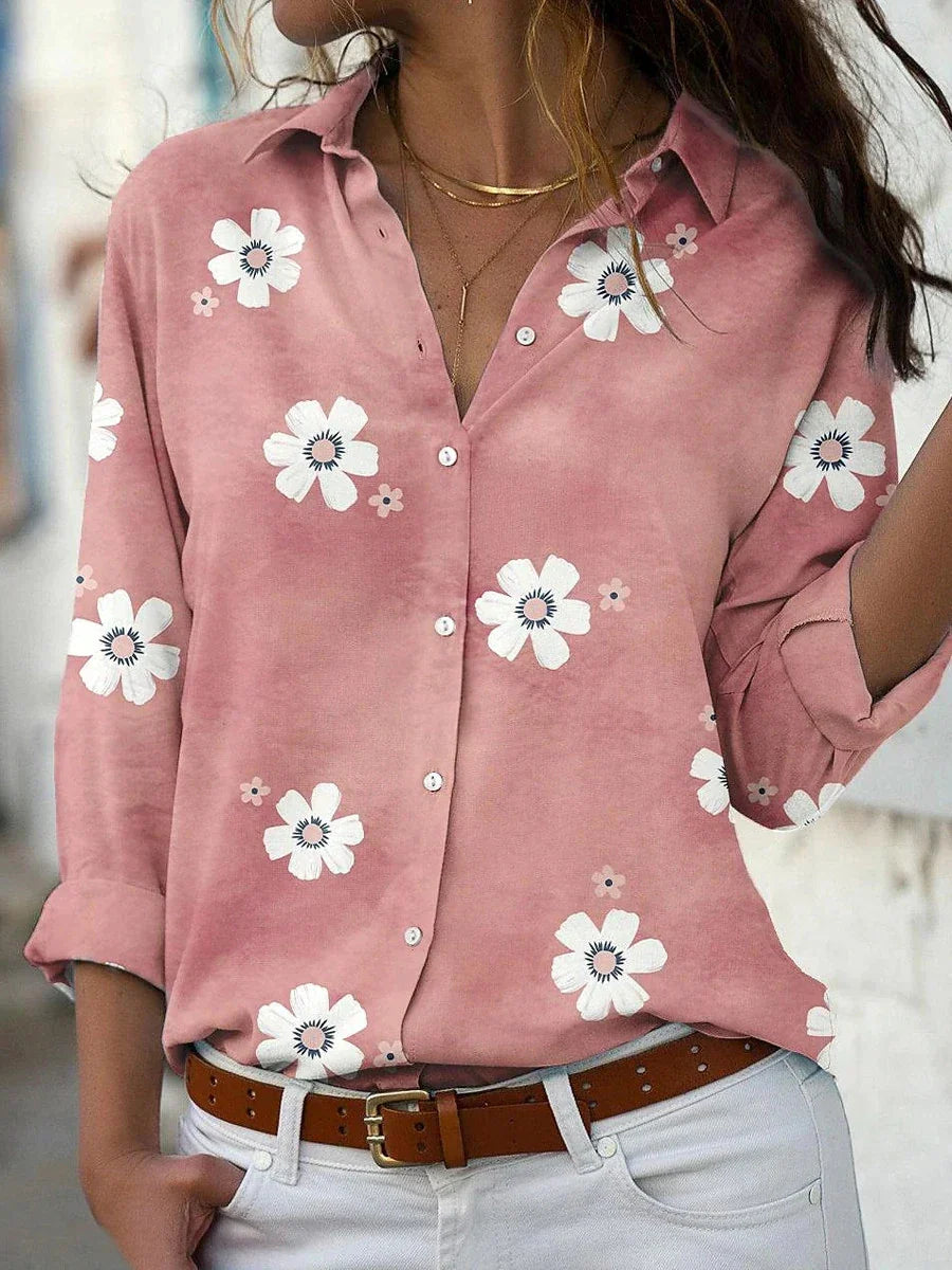 A women's summer blouse featuring a floral pattern and long sleeves, displayed on a mannequin. 0
