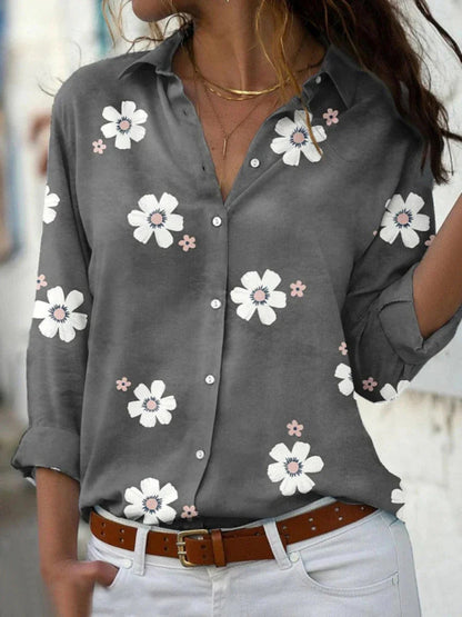 A women's summer blouse featuring a floral pattern and long sleeves, displayed on a mannequin. 1