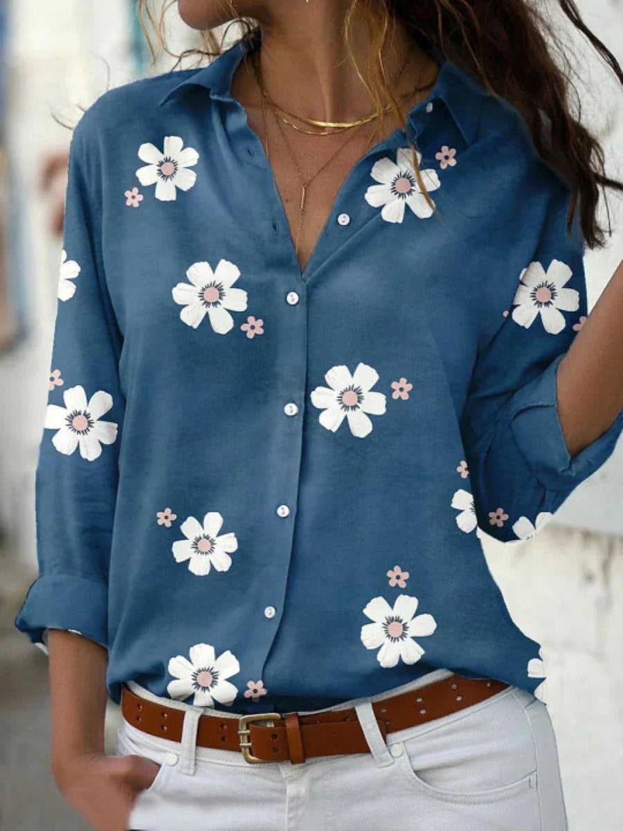A women's summer blouse featuring a floral pattern and long sleeves, displayed on a mannequin. 2