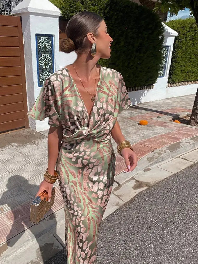 A midi dress with a V-neckline, featuring a wrap design, suitable for weddings and summer evenings. 1