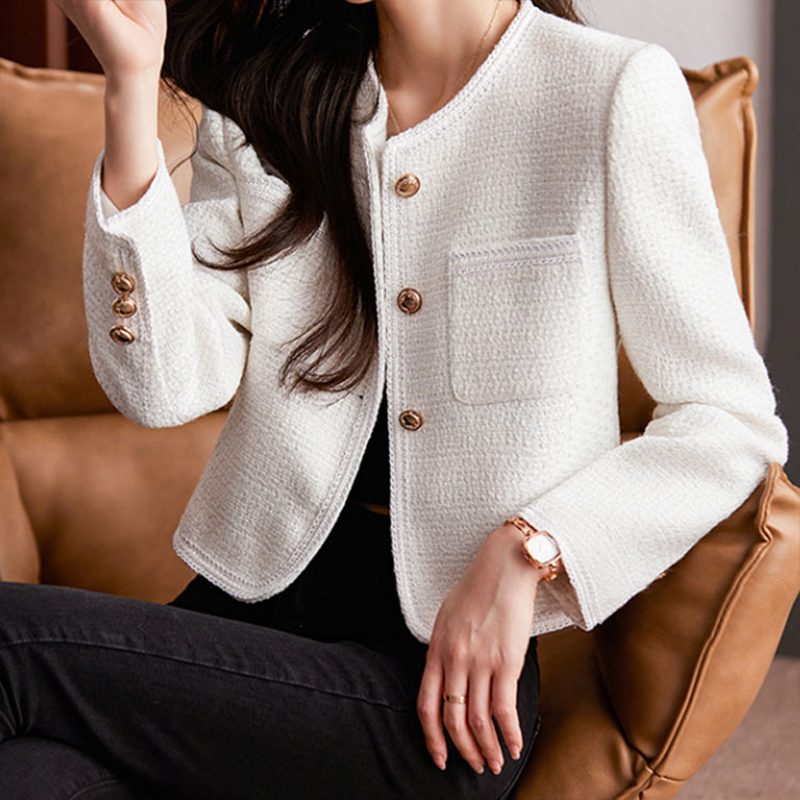 Short women's tweed blazer featuring a round neckline and metal buttons. 3