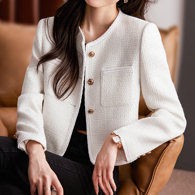 Short women's tweed blazer featuring a round neckline and metal buttons. 5