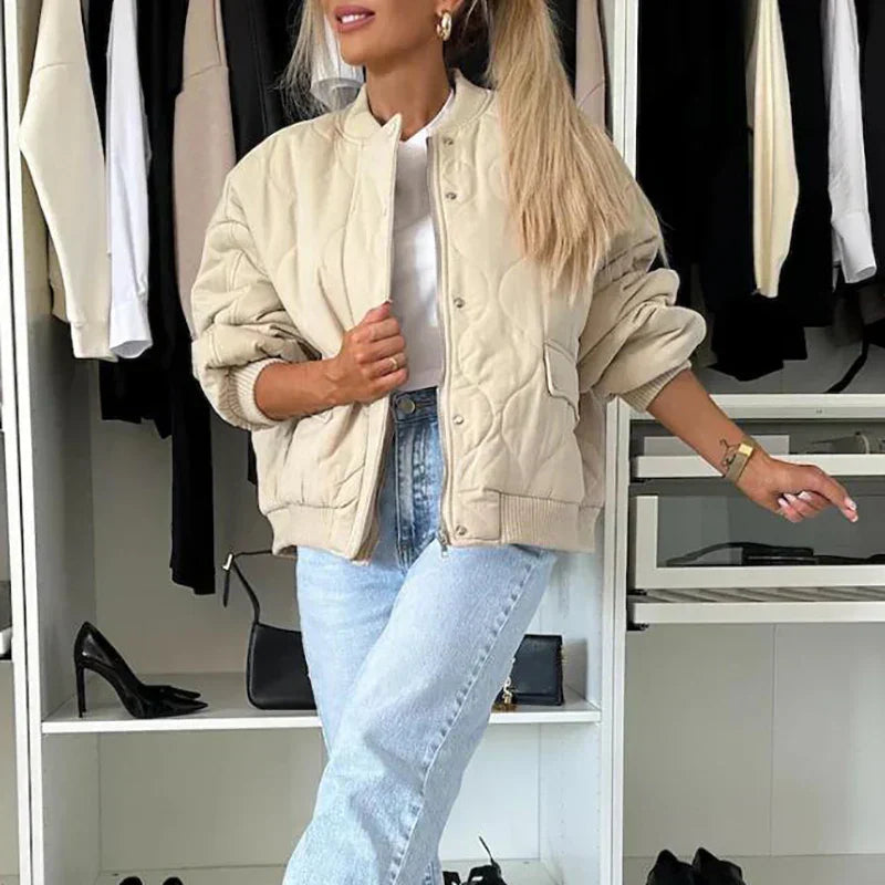 A women's quilted bomber jacket featuring a zip closure, displayed on a mannequin against a neutral background. 0