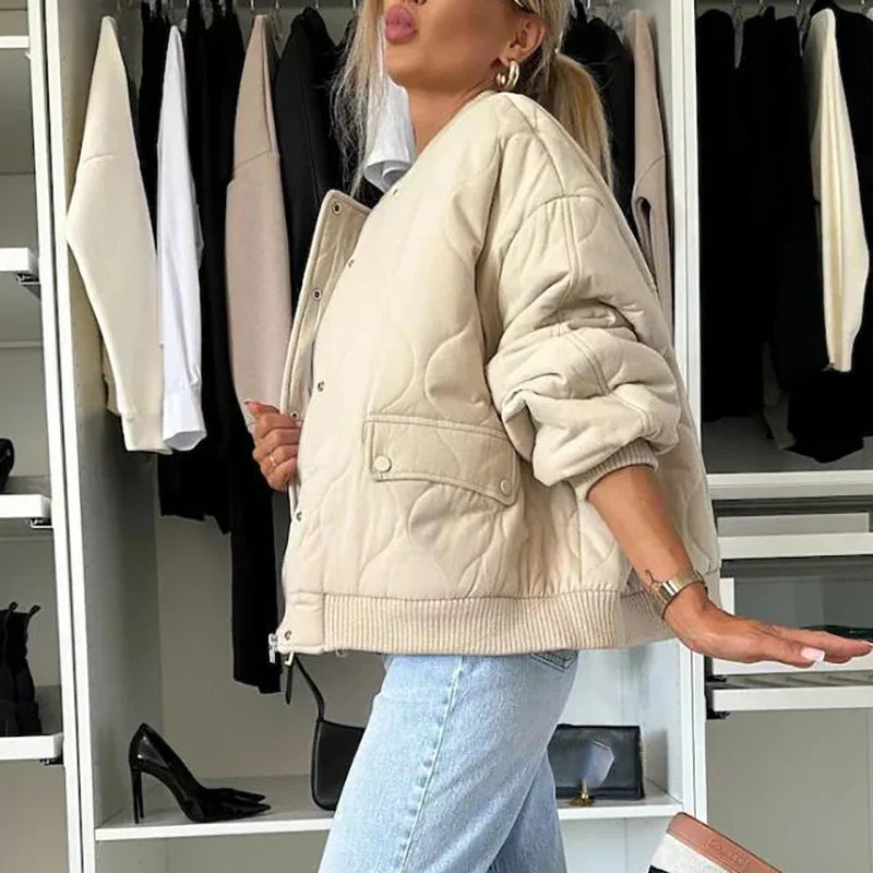 A women's quilted bomber jacket featuring a zip closure, displayed on a mannequin against a neutral background. 3