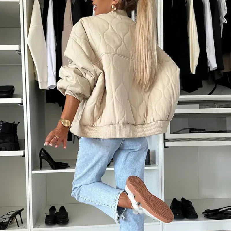A women's quilted bomber jacket featuring a zip closure, displayed on a mannequin against a neutral background. 4