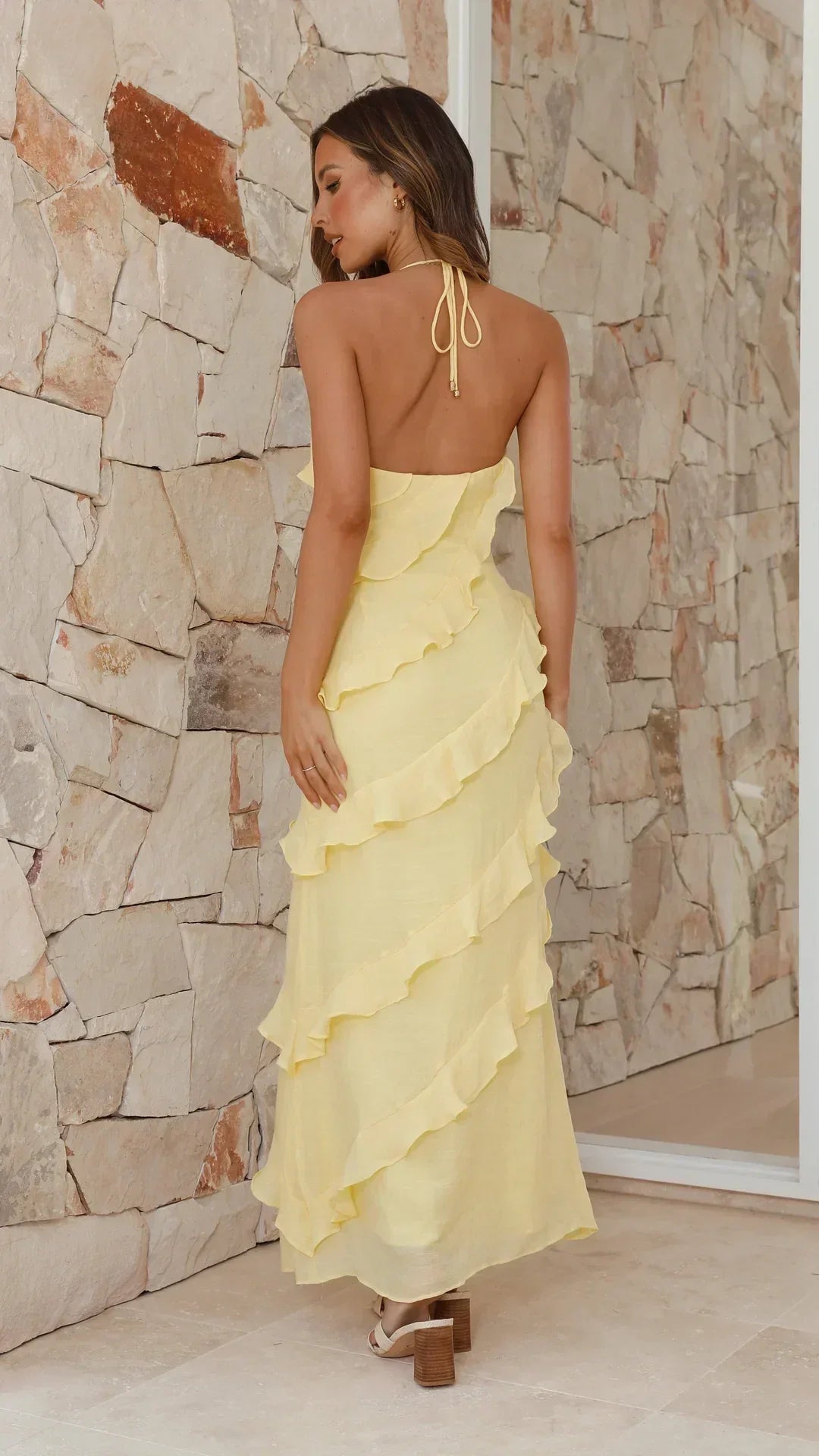 Maxi dress for women featuring a halter neckline and ruffles, designed for formal occasions such as weddings. 1