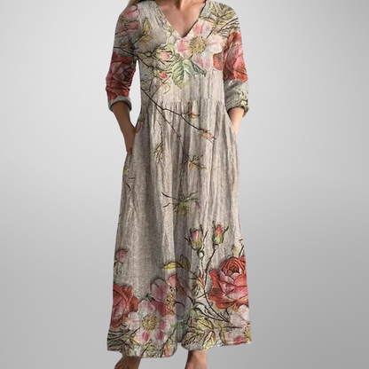 Maxi dress featuring a V-neckline and rolled sleeves, displayed on a mannequin against a neutral background. 0