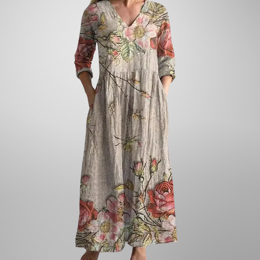 Maxi dress featuring a V-neckline and rolled sleeves, displayed on a mannequin against a neutral background. 0