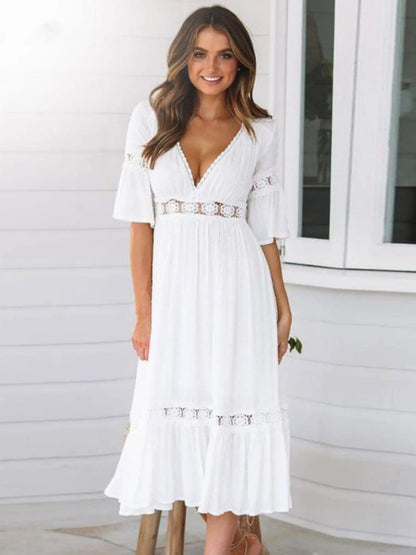 A midi dress featuring a V-neckline and an empire waist design, showcasing a flowing silhouette and a bohemian style. 0