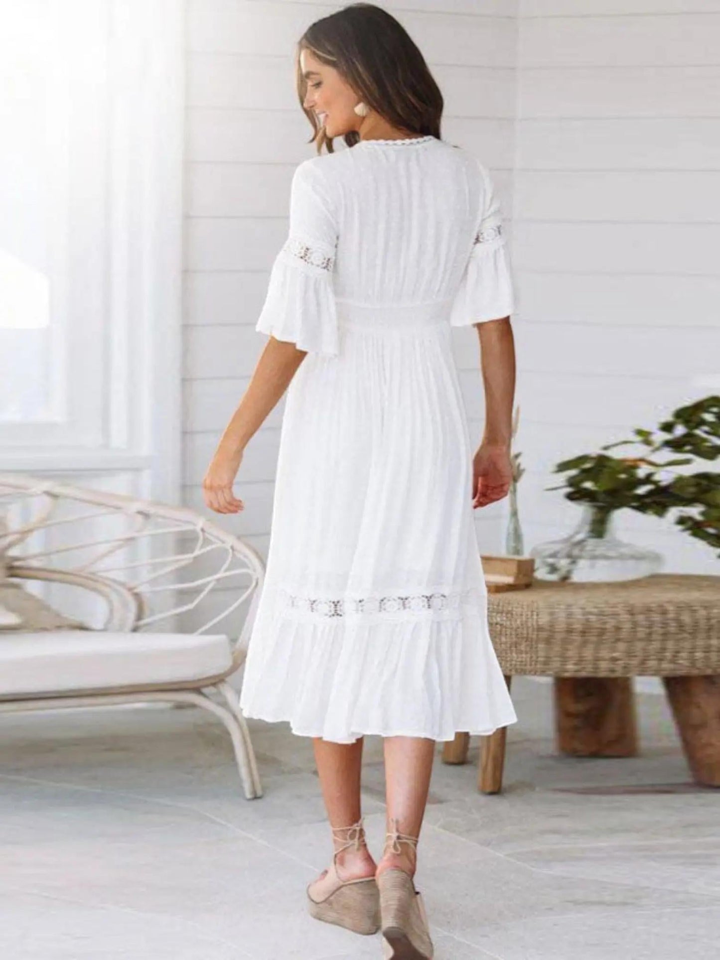 A midi dress featuring a V-neckline and an empire waist design, showcasing a flowing silhouette and a bohemian style. 1