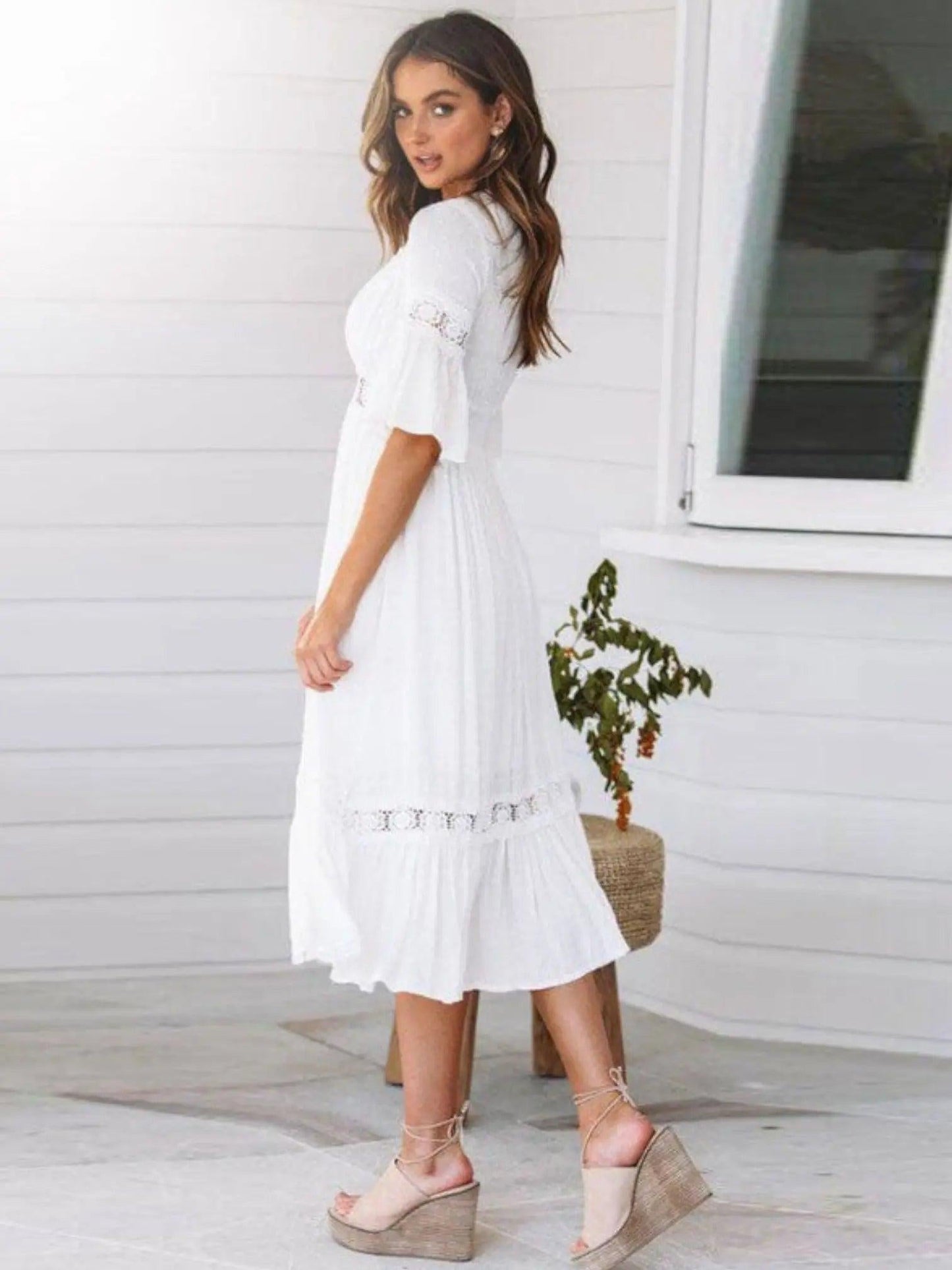 A midi dress featuring a V-neckline and an empire waist design, showcasing a flowing silhouette and a bohemian style. 2