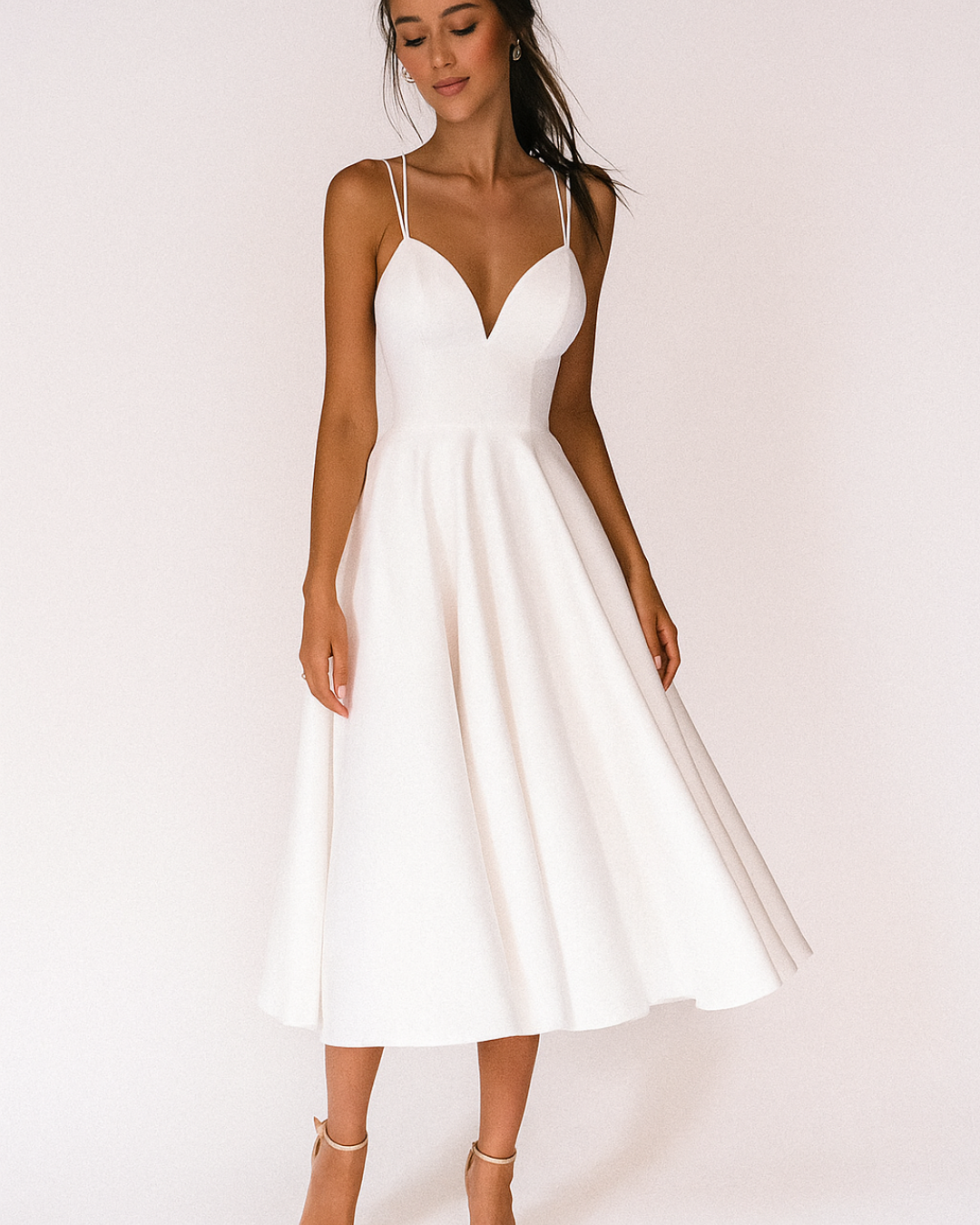 Dresses: A midi dress with spaghetti straps featuring an elegant accent, designed for formal occasions like weddings. 1