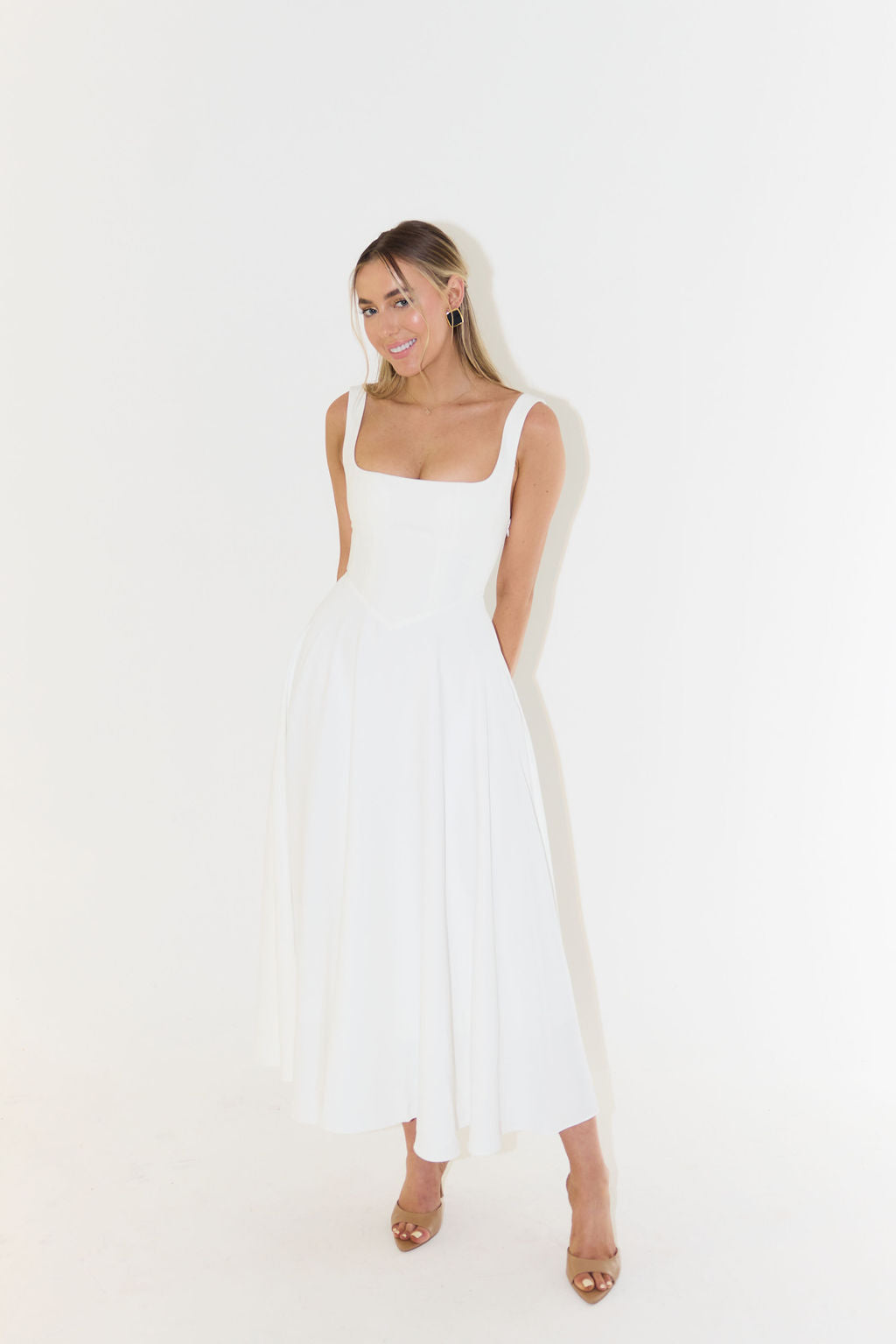 A midi dress for women featuring a fitted waist and a pleated skirt, designed for formal occasions like weddings. 3