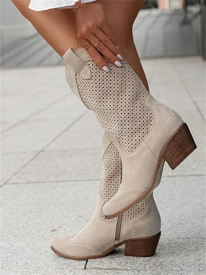 A pair of women's heeled cowboy boots featuring a cut-out design and a side zipper for easy wear. 4