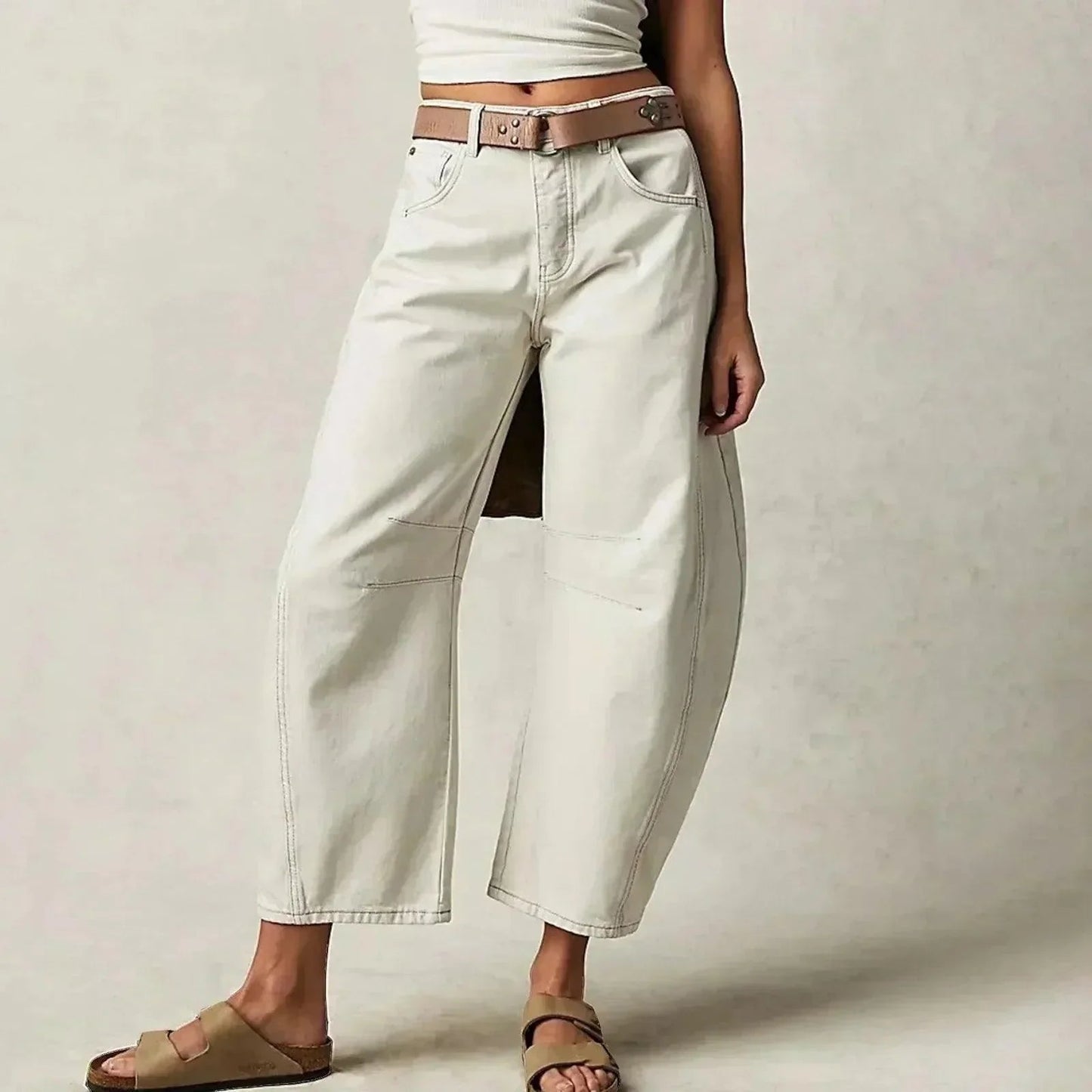 Loose high-waisted women's jeans displayed on a flat surface, featuring a relaxed fit and a classic five-pocket design. 2
