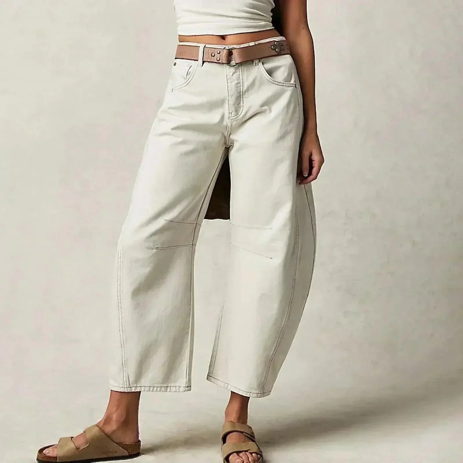Loose high-waisted women's jeans displayed on a flat surface, featuring a relaxed fit and a classic five-pocket design. 2