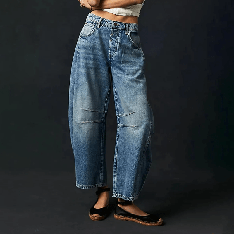 Loose high-waisted women's jeans displayed on a flat surface, featuring a relaxed fit and a classic five-pocket design. 4