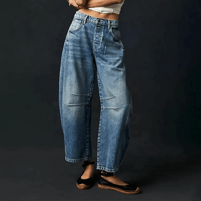 Loose high-waisted women's jeans displayed on a flat surface, featuring a relaxed fit and a classic five-pocket design. 4