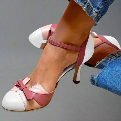 Classic women's pumps with a block heel featuring bow embellishments. 2