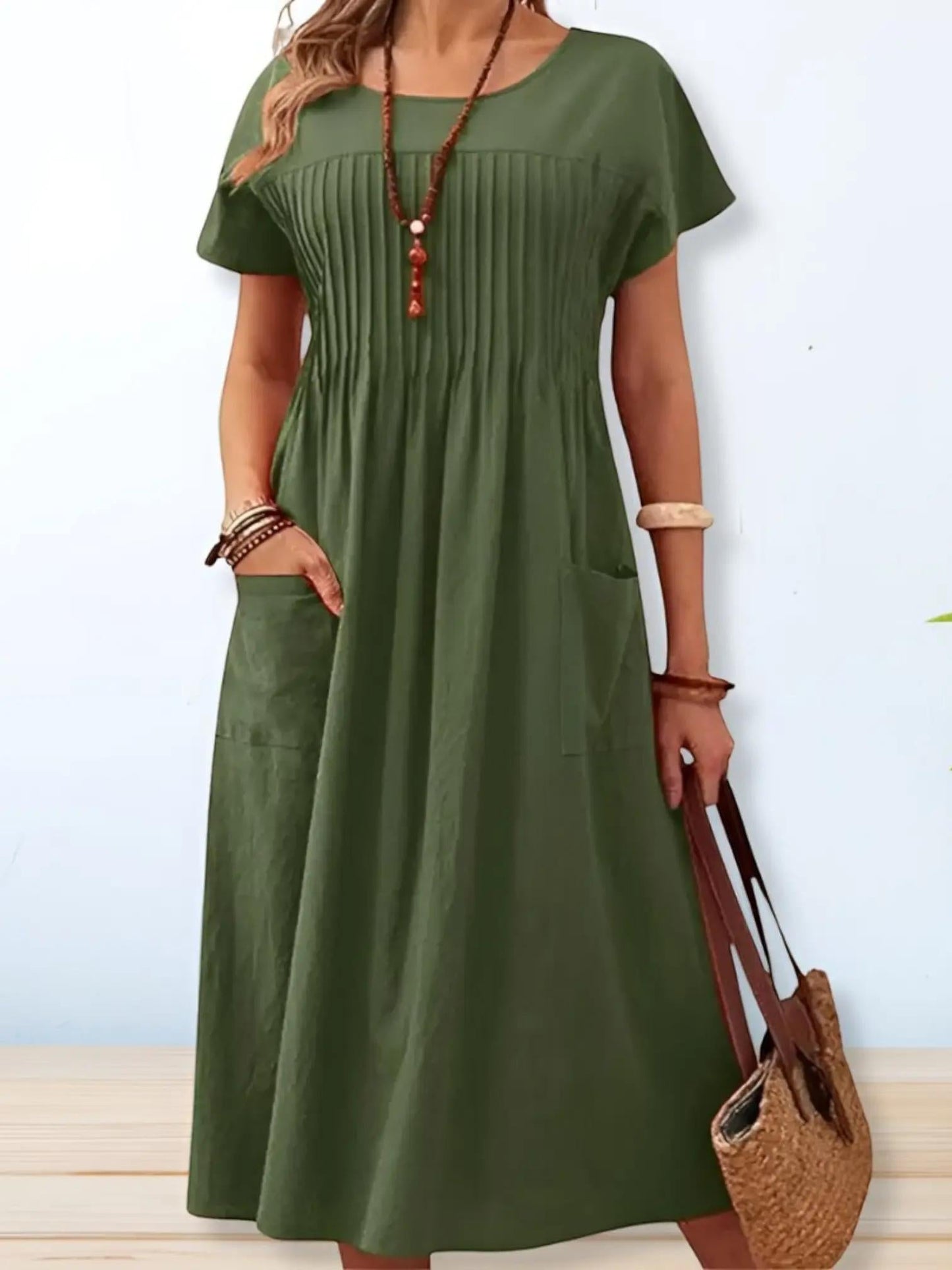 A midi dress with a loose fit and short sleeves, displayed on a mannequin. The dress has a simple, elegant design suitable for various occasions. 1