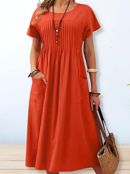 A midi dress with a loose fit and short sleeves, displayed on a mannequin. The dress has a simple, elegant design suitable for various occasions. 2