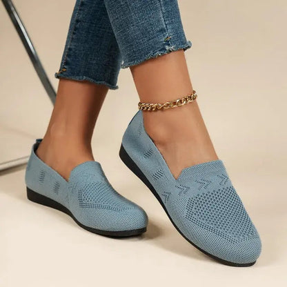 A pair of women's slip-on sneakers featuring a breathable upper design and a lightweight sole, displayed against a neutral background. 3