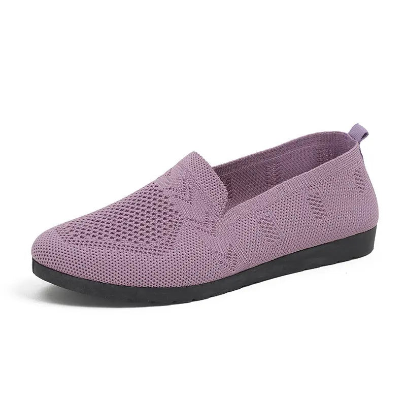 A pair of women's slip-on sneakers featuring a breathable upper design and a lightweight sole, displayed against a neutral background. 8