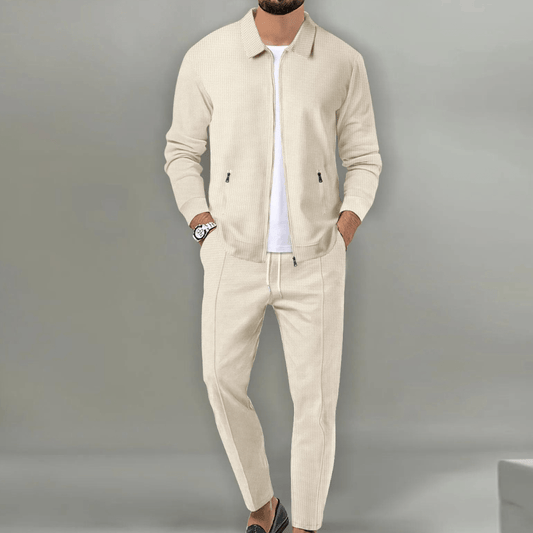 Men's beige blazer and pants set with a zipper closure, displayed on a neutral background. The blazer features a classic cut with lapels, while the 0