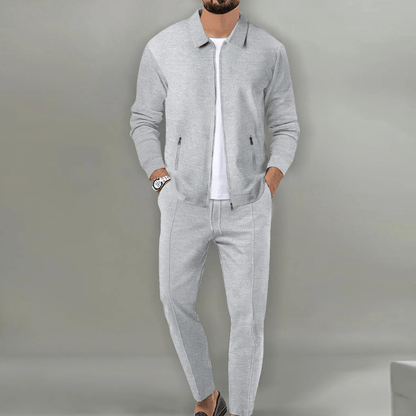 Men's beige blazer and pants set with a zipper closure, displayed on a neutral background. The blazer features a classic cut with lapels, while the 3