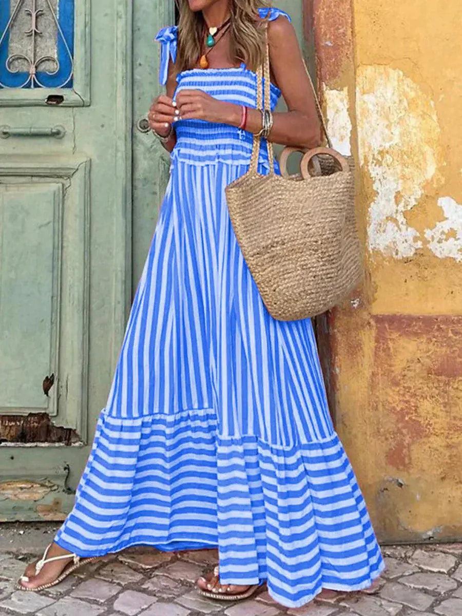 Maxi dress with a flowing silhouette and striped pattern, designed for weddings or summer outings, displayed on a hanger. 0