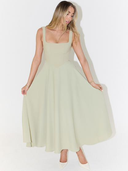 Midi dress featuring a square neckline and wide straps, designed for elegant occasions. The dress has a fitted bodice and a flowing skirt that falls to mid 2