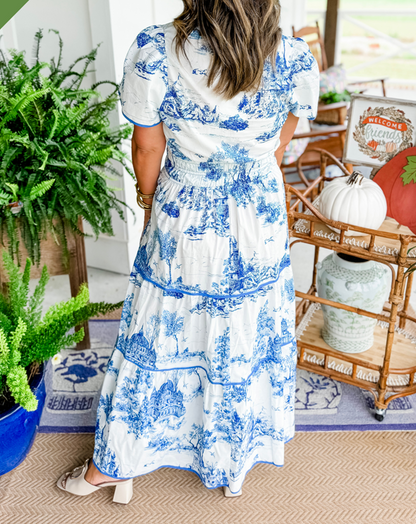 A women's maxi dress featuring a V-neckline and an A-line silhouette, displayed on a mannequin. The dress falls to the ankles, showcasing a flowing 4