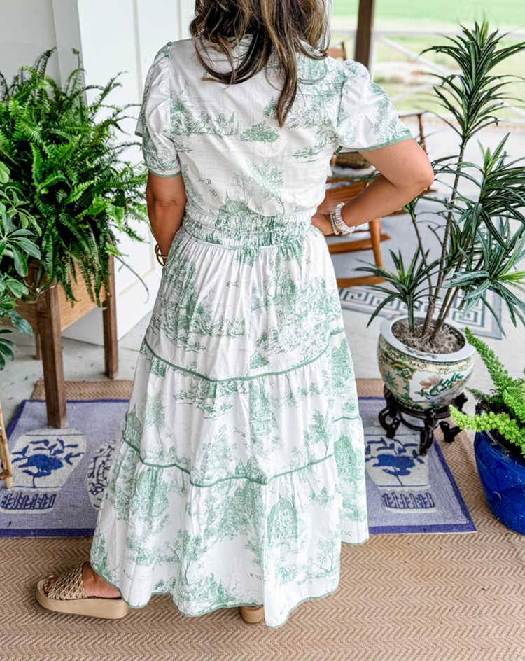 A women's maxi dress featuring a V-neckline and an A-line silhouette, displayed on a mannequin. The dress falls to the ankles, showcasing a flowing 7