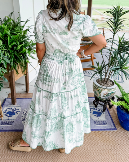 A women's maxi dress featuring a V-neckline and an A-line silhouette, displayed on a mannequin. The dress falls to the ankles, showcasing a flowing 7