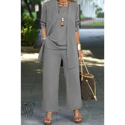 Three-piece women's casual set featuring a top, pants, and cardigan arranged neatly. The top has short sleeves, the pants are full-length, and the 7